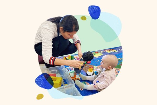 Woman playing with infant at childcare