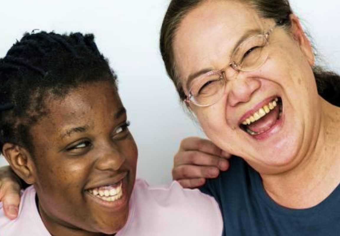 Two women of diverse backgrounds laughing